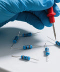 Gloved hand testing resistors from the 2600-Piece One Quarter Watt Metal Film Resistor Kit With 130 Values From One Ohm To Three Megaohm, One Percent Tolerance, Breadboard Friendly Assortment For DIY Electronics Repairs Projects And Pro Builds
