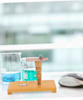 Inertia Demonstrator Hands On Pendulum Tool For Physics Classrooms on a wooden base with a metal rod in a science lab.