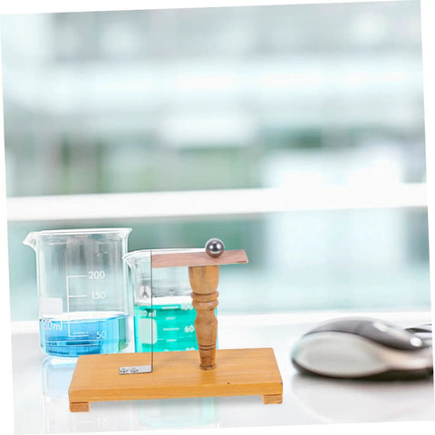 Inertia Demonstrator Hands On Pendulum Tool For Physics Classrooms on a wooden base with a metal rod in a science lab.