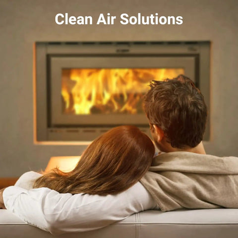 Couple sitting by a fireplace under text 'Clean Air Solutions', illustrating comfort and cleanliness with improved air quality.