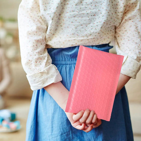 Person holding a pink bubble mailer from Pink Bubble Mailers Bulk Pack 60pcs Padded Envelopes 11x13 Inch With 4 Inch Sealing Flap