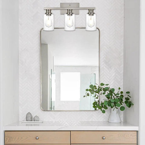 Three Light Wall Mount Bathroom Light Fixture In Brushed Nickel Finish With Seeded Glass Shade above mirror