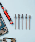10-Piece Tungsten Carbide Rotary Burr Set With Blue Case For Metal Deburring And Wood Carving beside electronic components on blue surface