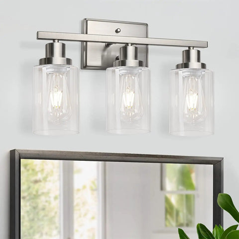 Killer 3 Light Wall Sconces With Clear Glass Shade And Brushed Nickel Finish mounted above a mirror, providing stylish illumination.