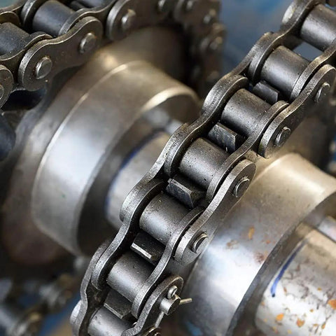 Close-up of a metal chain on a gear, used for heavy-duty machinery, ideal for Penetrating Lubricant For Metal Moving Parts, 17 Oz Can.