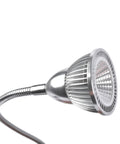 Close-up of silver adjustable lamp with metal grill shade and sleek design on flexible arm.