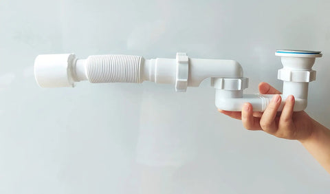 Hand holding Low Profile Shower Drain Trap Kit 1.5 Inch for Small Bathrooms, PVC, flexible, compact
