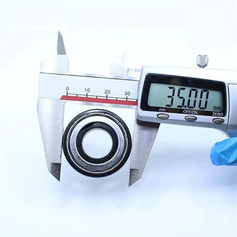 Measuring Badass High Temp 6202ZZ Deep Groove Ball Bearings 15X35X11MM rated for 500C with a digital caliper showing 35mm.