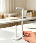 Large Thread Spool Stand For Sewing Machines on workspace, featuring a white 3D printed design holding thread spools.