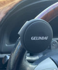 Universal Steering Wheel Spinner Knob With Bearing, black silicone, installed on car steering wheel for easy one-hand maneuvering.