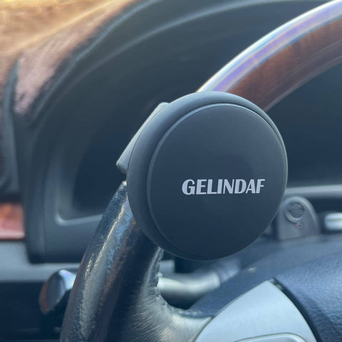 Universal Steering Wheel Spinner Knob With Bearing, black silicone, installed on car steering wheel for easy one-hand maneuvering.
