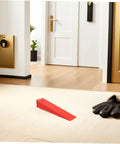 Heavy Duty Red Leveling Wedges 20 Pack Polymer Shims for Window and Furniture Installations on a floor with gloves nearby.