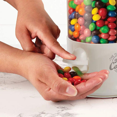 Stay Stocked On Your Favorite Treats Triple Compartment Candy Vending Machine Dispenser Pearl White, hands dispensing colorful candy.