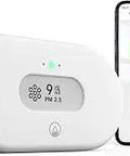 Smart PM25 Indoor Air Quality Monitor With Humidity And Temperature Readouts WiFi App Enabled Battery Powered next to smartphone display