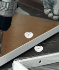 Kickstart Your Home Setup With Heavy Duty Peel And Stick Caster Wheels Featuring Stainless Steel Rollers For Furniture And Appliances Smooth Glide Movement Easy Install Durable Glides That Move Your Gear Hassle Free mounted on a wooden board with a drill.