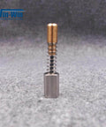 Electronic shift actuator assembly with brass top, coil spring, and gray base, front view.