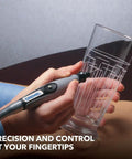 Dremel flex shaft rotary tool attachment with comfort grip; gray handle and long cable beside a clear glass