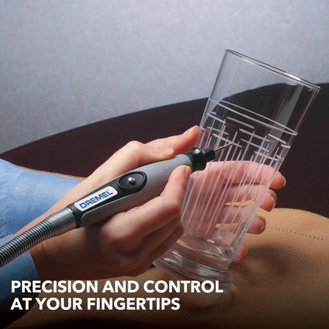 Dremel flex shaft rotary tool attachment with comfort grip; gray handle and long cable beside a clear glass