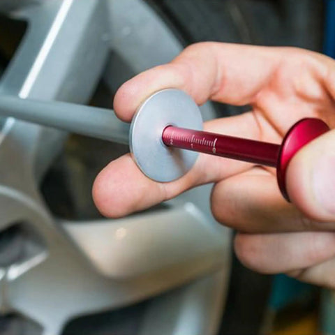 Person using Brake Disc Thickness Measurement Verniers Caliper to check disc thickness on a car wheel.