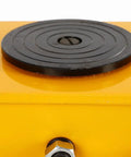 Close-up of a heavy duty machinery skate's black swivel plate on a yellow dolly, showcasing 360 degree rotation for 12 ton load.