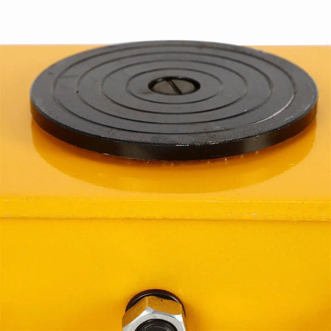 Close-up of a heavy duty machinery skate's black swivel plate on a yellow dolly, showcasing 360 degree rotation for 12 ton load.