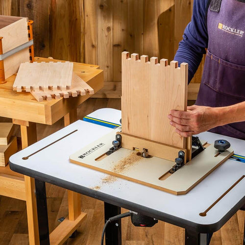 Person using Box Joint Router Jig With Precision Indexing For Router Table, working on smooth glide sled with wooden panel.