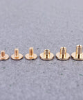 Top Shelf Copper Flat Head Rivet Screws, Thirty Pack Chicago Fasteners, copper fasteners in various sizes laid on fabric.
