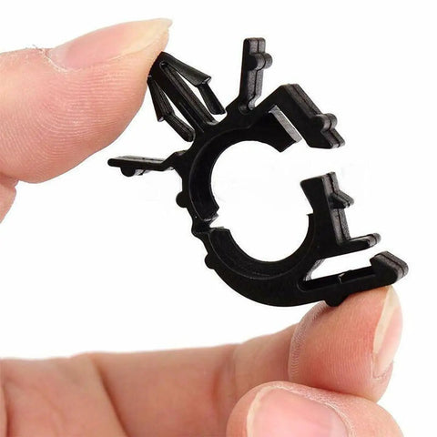 Hand holding a black clip from 60 Piece All In One Car Wire Loom Harness Routing Clips Kit 6 Size Assortment Releasable Push Mount Tie Wraps And Wiring Retainers Durable Nylon Universal Clips For Vehicle Boat Trailer UTV And More.