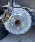 Street Tough M12x1.5 Wheel Studs And 43mm Lug Bolts 5 Piece Kit with brake rotor and caliper on Honda vehicle.