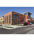 Commercial building exterior with glass windows and red car, potential location for High Output 5,500 Lumen LED Flood Light for Outdoor Use.