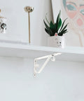 Heavy Duty Corner Shelf Brackets Wall Mount Supports Rock Solid Iron L Brackets Built Like A Tank For Diy Wood Shelving And Workshop Storage Super Sturdy Black Metal Braces Zero Stress Setup mounted on a white wall, showing support for shelves.