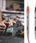 Beefed-Up 1000V 20A Multimeter Lead Kit With Comfort Grip Probes, red and black test leads in use on circuit board.