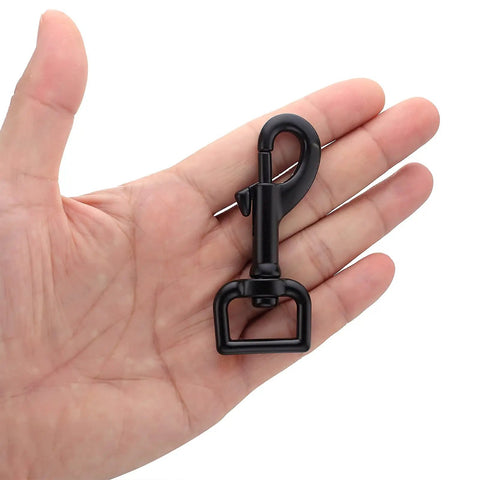 Top Tier Hella Sturdy Black Swivel Eye Bolt Snap Hook held in hand, showcasing zinc alloy build for pet gear.
