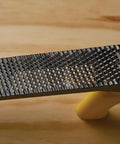Close-up of a Metal Body Surform Plane For Precision Shaping And Smoothing, 11.8 Inch Hand Tool With Interchangeable Blades on wood