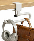 Heavy Duty Clamp On Desk Hook For Bags And Backpacks With Anti Slip Grip Extended Clearance Bag Holder For Office And Gaming Desks Adjustable From 0.19 To 1.57 Inches White, holding headphones and brown bag on wooden desk