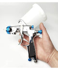 Heavy Duty Pneumatic Paint Sprayer With 400Cc Metal And Plastic Cups For Cars And Trucks Includes 1.3Mm And 1.8Mm Nozzles in hand.