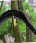 Manganese Steel Hand Scythe For Weeding And Cultivation With Comfortable Grip, cutting a tree branch outdoors, showing blade detail