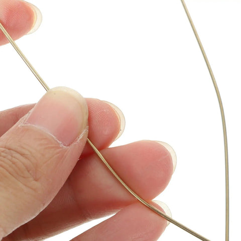 Hand holding a Top Tier Copper Welding Rods Kit 4pcs for Jewelry Making Golden Metal Sticks Soldering Wire.