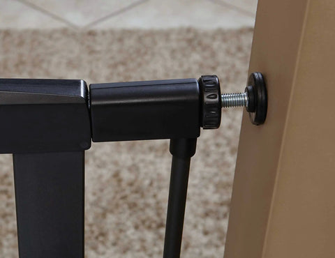 Close-up of 29 Inch High Walk Through Pressure Mounted Steel Dog Gate Expands From 29 To 38 Inches Wide with mounting detail on textured graphite