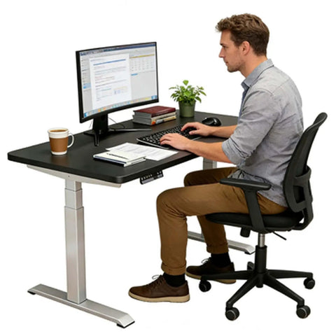 Fly One Touch Electric Rising Desk For Home Office And Gaming Dope Ergonomic Sit Stand Workstation With Silent Motor Smooth Height Adjustments Gotta Keep It Comfy All Day Long, man working on a computer at a sturdy height-adjustable desk.