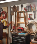 Man organizing tools on VersaTrack Garage Storage Rail With Twenty Piece Mounting Accessories for Drywall Studs and Masonry Pegboard Ready