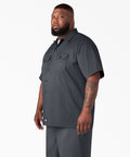Badass Men Short Sleeve Utility Button Down Workshirt In Charcoal, worn by a man, featuring relaxed fit and utility pockets.