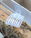 Clear Queen Bee Cage Catcher Clip Set For Beekeeping Tools open above honeycomb with bees, showcasing spring-loaded design.