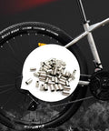 50 Pack Bike Cable End Caps And Brake Cable Ends Aluminum Alloy Crimps against bicycle wheel backdrop