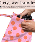 Hand placing item in Coral Pink Polka Dot Wet Bag And Dry Bag For Beach And Pool Waterproof, Machine Washable And Reusable Swim Tote.
