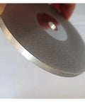 Close-up of Double Sided Lapidary Diamond Grinding Disc Wheel, 4 Inch Ceramic Disk, edge view showing texture and thickness.