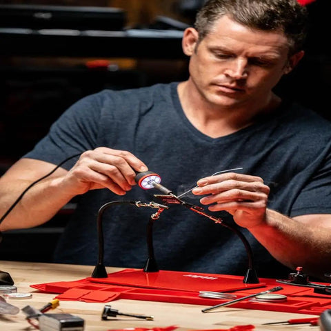 Man using a 5 to 30 Watt Precision Soldering Iron Station with adjustable wattage, compact 120V design, for pro crafters and DIY enthusiasts