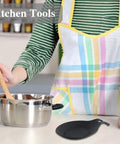 Person stirring pot with spoon, black silicone rest from Three Piece Silicone Spoon Rest Set For Stove Top And Kitchen Counter visible