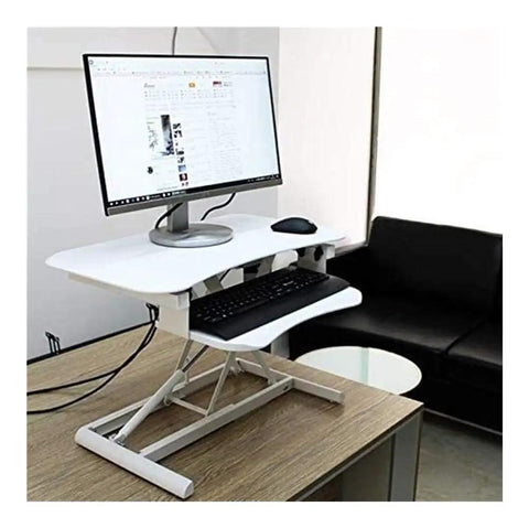 Stylish White Standing Desk Converter With Smooth Gas Spring Lift For Laptop Or Monitor on a wooden table with a monitor and keyboard.
