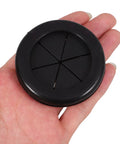 Black Rubber Grommet Kit For Cable Management With Dual Sided Buckle Design, Fire Resistant And Waterproof Desk Hole Cover For Office And Home Use, Includes Four Pieces. Black rubber cable hole cover shown in hand, round desk grommet for two cables.